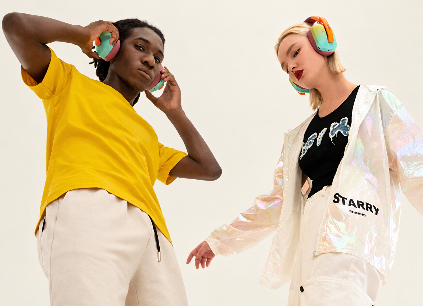 Two listeners wearing colorful over-ear headphones